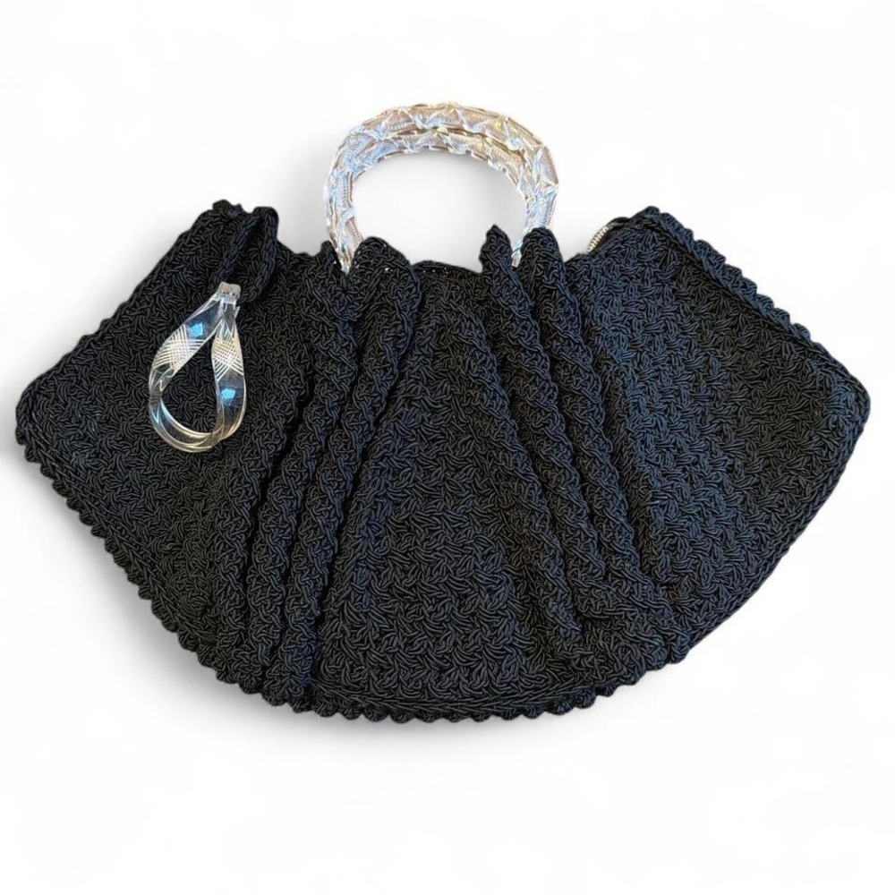 Black crocheted corde handbag featuring a clear, twisted Lucite handle